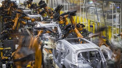Robotic arms work on cars on a production line: Qilai Shen/Bloomberg