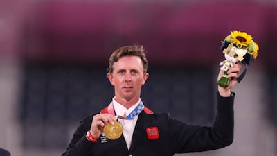 Ben Maher of Great Britain poses on the podium with his gold medal after winning the Jumping Individual Final.