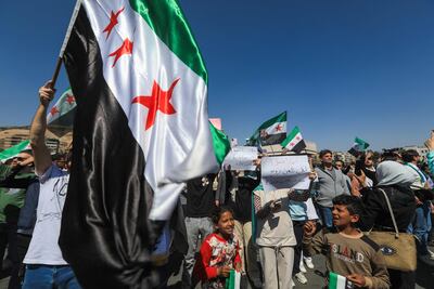 Syrians celebrating the fall of Bashar Al Assad wave the flag representing the opposition. AFP