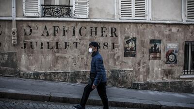 A man wearing a face mask walks on a deserted street transformed into a movie set, in Paris, France. EPA