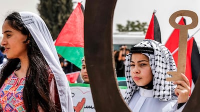 A girl at a demonstration in the occupied West Bank on Tuesday holds a mockup of a traditional key, symbolising the homes lost by Palestinians in the Nakba of 1948. AFP