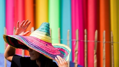 A reveller wears a rainbow coloured hat at Glastonbury Festival in Somerset, Britain. Reuters