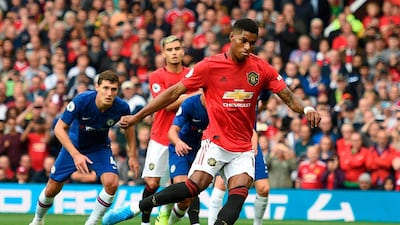 Manchester United's English striker Marcus Rashford (C) shoots to score from the penalty spot for the opening goal during the English Premier League football match between Manchester United and Chelsea at Old Trafford in Manchester, north west England, on August 11, 2019. RESTRICTED TO EDITORIAL USE. No use with unauthorized audio, video, data, fixture lists, club/league logos or 'live' services. Online in-match use limited to 120 images. An additional 40 images may be used in extra time. No video emulation. Social media in-match use limited to 120 images. An additional 40 images may be used in extra time. No use in betting publications, games or single club/league/player publications. / AFP / Oli SCARFF / RESTRICTED TO EDITORIAL USE. No use with unauthorized audio, video, data, fixture lists, club/league logos or 'live' services. Online in-match use limited to 120 images. An additional 40 images may be used in extra time. No video emulation. Social media in-match use limited to 120 images. An additional 40 images may be used in extra time. No use in betting publications, games or single club/league/player publications.
