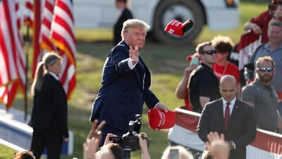 Mr Trump tosses Maga hats to the crowd as he arrives for a Save America rally at the Delaware County Fairgrounds in Delaware, Ohio. EPA