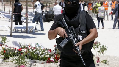 A hooded Tunisian police officer stands guard at the scene of the terror attack on Sousse. (Abdeljalil Bounhar /AP)