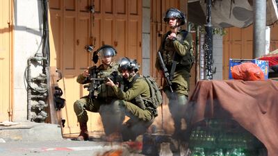 Israeli soldiers take positions during clashes with Palestinians following a protest in the West Bank city of Hebron on February 18. Israeli forces have killed a Palestinian fighter in a raid on the Jenin refugee camp in the occupied West Bank, according to the Palestinian health ministry. EPA