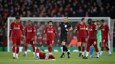 Liverpool's Virgil van Dijk after sustaining an injury while Roberto Firmino, Sadio Mane and teammates look on. Reuters