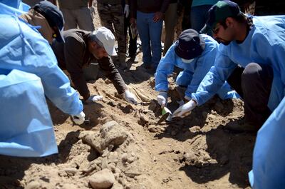 An Iraqi forensic team exhumes the bodies of soldiers killed by ISIS from a mass grave in Tikrit, north-west of Baghdad, in 2015. Reuters