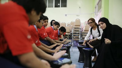 Nadia Ghenia, left, coordinator of the Smart campaign, and Dr Hagar Badawi, of the Majid Al Futtaim Charity Foundation, teach pupils in Grades 8 and 9 at Dubai Modern Education School how to take their pulse. Youngsters are also also taught about counting calories and the glycemic index. Sarah Dea / The National