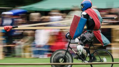 People dressed as knights ride bicycles at the Berlin Pedal Battle games. EPA