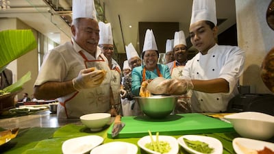 Philippine Ambassador Grace Relucio Princesa, center, mixes ingredients while attending a Thai cooking class at Eastern Mangroves Resort & Spa, with ambassadors from India, Malaysia, Indonesia, and Mexico which was hosted by the Thai ambassador Warawudh Chuwiruch. Christopher Pike / The National