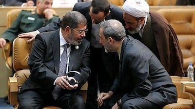 The Egyptian president Mohammed Morsi, left, with, Ali Akbar Velayati, an adviser to the Iranian supreme leader, on right, and officials during the Non-aligned Movement summit in Tehran on Thursday.
