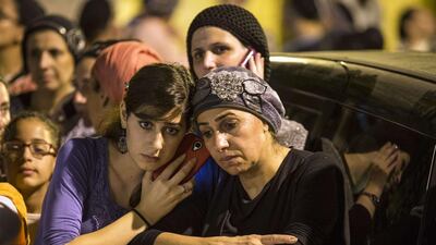 Israelis gather on June 30, 2014 in the Israeli city of El'Ad, outside the house of Eyal Yifrach, one the three missing teenagers, after Israel confirmed that their bodies were found in a field near Halhul. Any Israeli action to punish Hamas for the alleged murder of the three teenagers would open "the gates of hell," the Islamist movement warned. AFP Photo