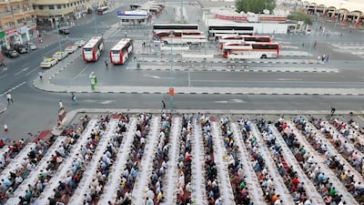 People sit together to break their fast in the parking area near the Al Ghubaiba Bus Station in Bur Dubai. Pawan Singh / The National