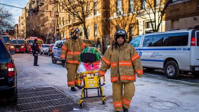Police stand guard as paramedics leave the scene near the building 12 people died in a fire in the Bronx borough of New York. Andres Kudacki/ AP Photo