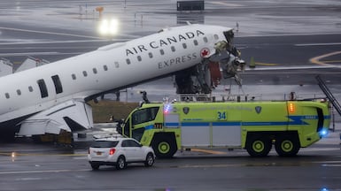Emergency crews respond to an Air Canada Express plane on the tarmac after the plane collided with a fire engine at LaGuardia Airport in New York yesterday. Bloomberg