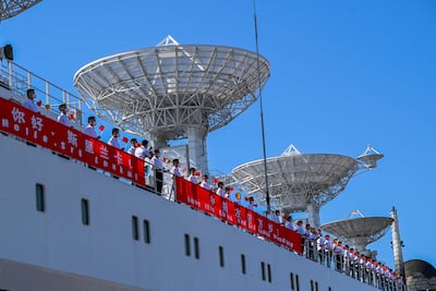 Crew members aboard China's research and survey vessel, 'the Yuan Wang 5', hold Chinese national flags upon their arrival at Hambantota port on August 16, 2022. AFP