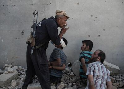 An Iraqi army soldier silences an alleged ISIS fighter taken in custody inside the old city in Mosul. Photo by Alessio Romenzi