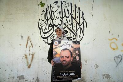 Dalal Awawdeh poses with a poster of her imprisoned husband Khalil Awawdeh at their home, in the West Bank village of Idna. AP