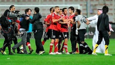Quique Sanchez Flores, left, was slapped in the back by Al Wasl goalkeeper Majed Naser, second right.
