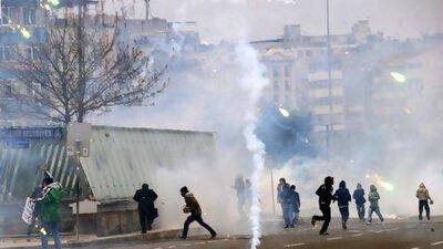 Kurdish protesters run away from tear gas during clashes with riot police in a street demonstration on Tuesday.