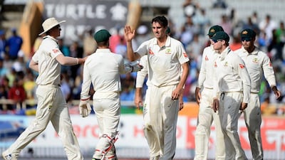 Pat Cummins, centre, celebrates with Australia teammates after claiming the wicket of India's Ravichandran Ashwin on Saturday. Sajjad Hussain / AFP