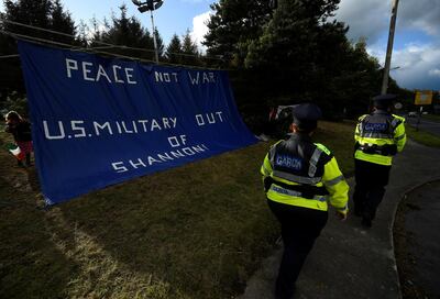 Irish police officers pass by an anti-U.S. President Donald Trump sign as people demonstrate in a camp they have set up outside Shannon Airport in Shannon. Reuters