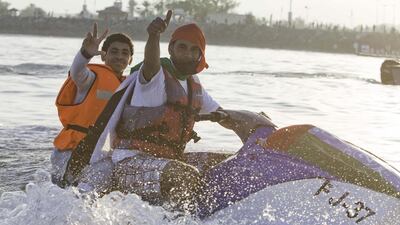 Two young men on jet ski at a boat parade marking the 42nd UAE National Day in Fujairah. Jaime Puebla / The National