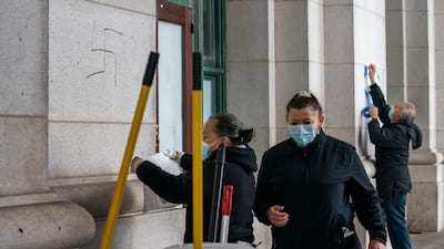 A cleaning crew covers hand-drawn swastikas on the front of Union Station. AP