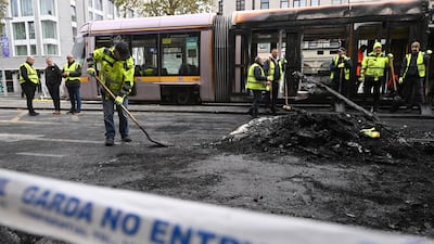 Workers clean the debris of a burnt train, in Dublin, Ireland, on Friday. Getty Images
