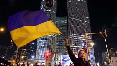 A woman in Israel's city of Tel Aviv waves a Ukrainian national flag during a protest against Russia's military invasion of Ukraine. AFP