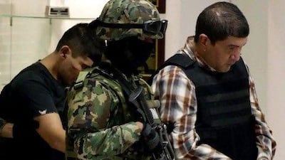 The alleged leader of a faction of the hyper-violent Zetas cartel, Ivan Velazquez Caballero, known as ‘El Taliban’, right, is escorted by navy guards after being captured.