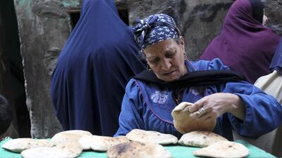 A woman chooses bread to buy at a bakery in Cairo. Mohamed Abd El Ghany / Reuters