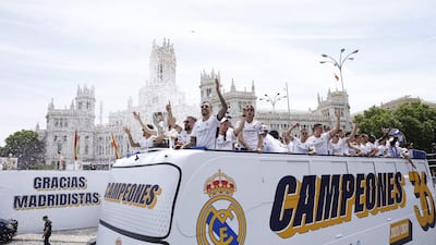 TOPSHOT - Real Madrid's Spanish forward #14 Joselu and teammates parade onboard a bus as they celebrate their 36th LaLiga trophy at the Cibeles square in Madrid on May 12, 2024. Real Madrid's fans line the streets of Madrid as 'Los blancos' celebrate their 36th Liga trophy before facing Borussia Dortmund at Wembley in the Champions League final on June 1. (Photo by OSCAR DEL POZO / AFP)