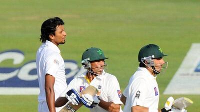 Pakistan batsman Younis Khan, centre, and Misbah-ul-Haq, right, run between the wickets as Sri Lankan bowler Suranga Lakmal looks on during the second day of their first cricket Test match at the Sheikh Zayed Stadium in Abu Dhabi on Wednesday. AFP PHOTO/Ishara S. KODIKARA