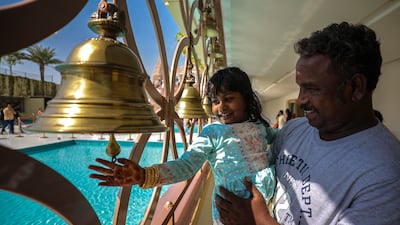 A little girl sounds a bell for good luck on the first day of Diwali at the Baps Hindu Mandir temple in Abu Dhabi. Victor Besa / The National
