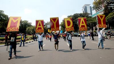 Indonesians hold placards as they march along a road toward the Presidential Palace in Jakarta. Bagus Indahono / EPA