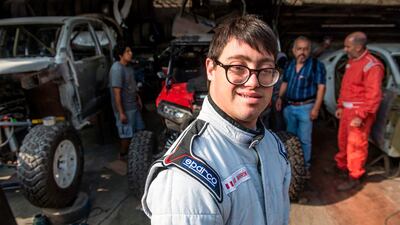 Lucas Barron, 25, smiles at a mechanics workshop in Lima where his car is being prepared to take part in the upcoming Dakar Rally. AFP