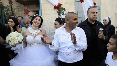 Groom Mahmoud Mansour, 26, (C) and his bride Maral Malka, 23, celebrate with friends and family before their wedding in Mahmoud's family house in Jaffa, south of Tel Aviv August 17, 2014. Israeli police on Sunday blocked more than 200 far-right Israeli protesters from rushing guests at the wedding of a Jewish woman and Muslim man as they shouted "death to the Arabs" in a sign of tensions stoked by the Gaza war. Picture taken August 17, 2014. Reuters