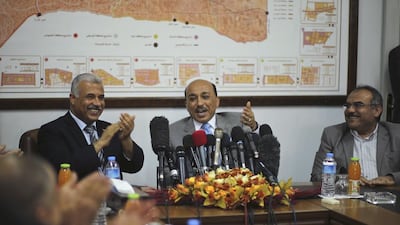 Mufeed Al-Hassayna, the Palestinian minister of housing and public works, centre, gestures as he sits next to former Hamas government minister of housing Youssef Graze, left, during an office handover ceremony in Gaza City on Wednesday. Mohammed Salem / Reuters