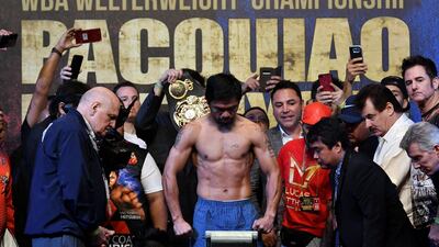 Manny Pacquiao gets weighed as supporters and officials watch on. Reuters