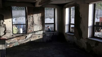 An Afghan security policeman is seen through a window of a Shiite mosque where gunmen attacked during Friday prayers, in Kabul, Afghanistan. Rahmat Gul / AP Photo