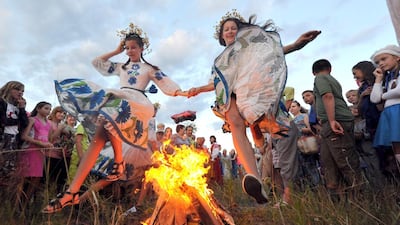 Wearing traditional Belarus costumes girls jump over a bonfire as they celebrate the Ivan Kupala night, an ancient heathen holiday, held in the countryside near the town of Turov, some 260 km southwest of the capital Minsk, on July 6, 2014. People celebrate Kupala Night with bonfires that last throughout the night with some leaping over the flames as it is believed that the act of jumping over the bonfire cleanses people of illness and bad luck. AFP