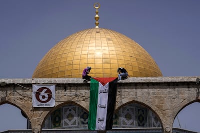 Masked Palestinians hang the national flag during Ramadan in front of the Dome of the Rock shrine at the Al Aqsa Mosque compound in Jerusalem's Old City in April. AP Photo