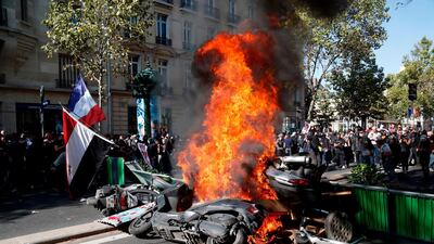 Motorcycles burn next to a barricade erected across a street during a Climate Change protest in Paris, France. AFP