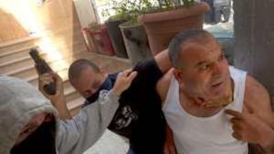 Plainclothes Israeli policemen, centre and left, arrest a Palestinian man during clashes in Arab East Jerusalem yesterday.