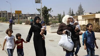 Women and their children leave the Moadamiyeh suburb of Damascus on September 2, 2016, following a deal struck with the government. AP Photo