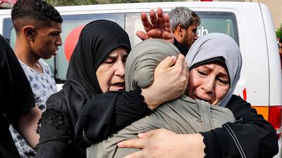 Palestinian women console one another outside a morgue in Khan Younis after identifying loved ones killed in an Israeli air strike. AFP