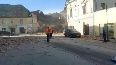 A grab of a video taken and released by the Croatian Red Cross on shows people looking through the rubbles and rescuing victims in the streets of Petrinja, after the town was striked by an earthquake of 6,4 magnitude. AFP