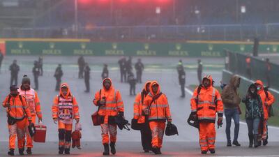 Race marshalls walk on the track after the race was suspended. AFP